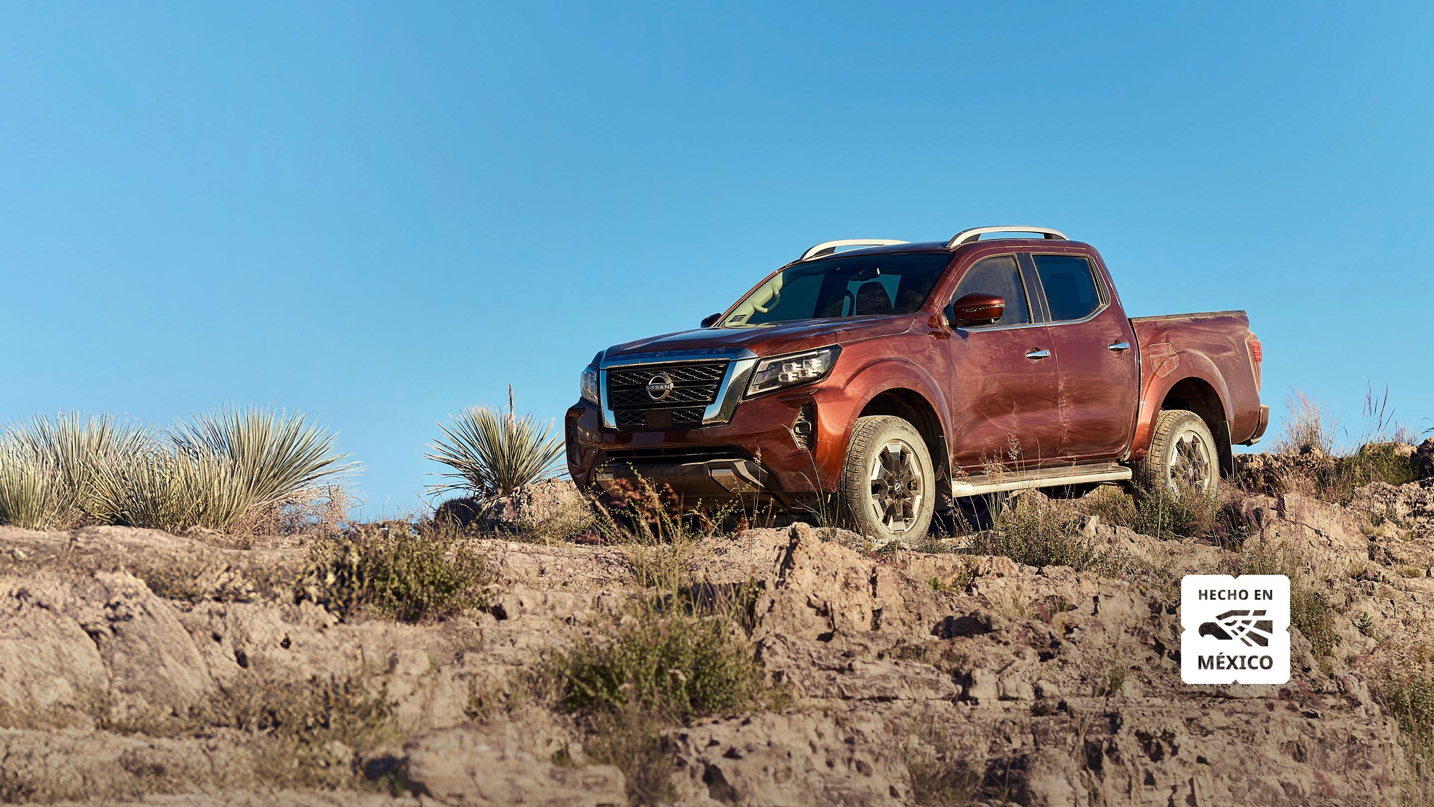 2026 Nissan Frontier PLATINUM LE DIESEL 4X4 TA in Rojo, Plata, Gris Oxford, Gris Volcánico, Negro, Blanco — front three-quarter view